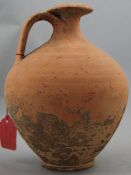 A Roman terracotta flagon, c.2nd century AD, of ovoid form with saturn disc neck and looped