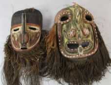 A Papua New Guinea Sepik River carved wooden ceremonial mask, with integral handle, polychrome