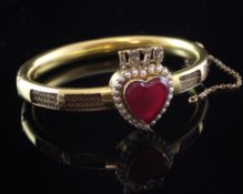 A Victorian high carat gold, seed pearl and diamond set mourning hinged bangle, with central red