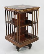 An Edwardian mahogany and satinwood banded revolving bookcase, the top with central circular fan