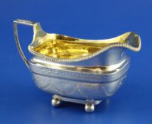 A George III silver cream jug, of rounded rectangular form, with bright cut engraved decoration,