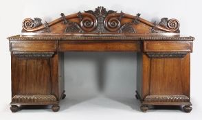 A large 19th century Anglo Indian rosewood pedestal sideboard, the shaped scrolling back rail carved