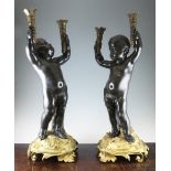 A pair of late 19th / early 20th century French bronze and ormolu torcheres, each modelled as a