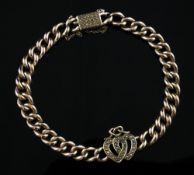 An early 20th century gold curb link bracelet with central twin hearts motif set with seed pearls,