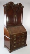 A Queen Anne walnut and featherbanded bureau cabinet, the double dome top with a pair of cupboard