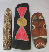 A Papua New Guinea Sepik River carved wooden shield, painted with a bold abstract design in white,