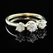 An 18ct gold and three stone diamond ring, set with three claw set old mine cut diamonds, size P.