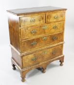 An 18th century walnut and featherbanded chest on stand, fitted two short and two long drawers,