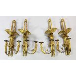 A set of four French Empire style carved giltwood wall lights, each with eagle and fleur de lys