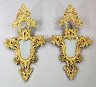 A pair of 20th century Italian carved giltwood cartouche shaped wall mirrors, with large pierced