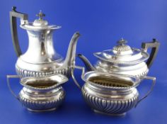 An Edwardian four piece demi fluted silver tea and coffee set, in a fitted two-handled oak