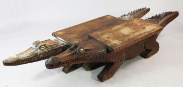 Papua New Guinea, a near pair of carved wooden low tables, in the form of crocodiles with incised