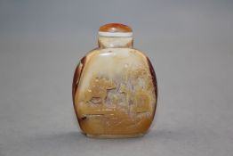 A Chinese hornbill snuff bottle and stopper, 1900-1940, carved in high relief with figures and