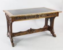 A late 19th / early 20th century Gothic carved oak library table, the rectangular top inset with