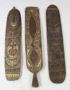 A Papua New Guinea Sepik River carved wooden gope board, with incised linear design; and two similar