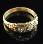 A late Victorian 18ct gold and gypsy set six stone diamond ring, with carved shoulders, size T.