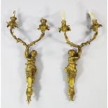 A pair of French Louis XV style ormolu twin branch wall lights, each modelled as a putto holding