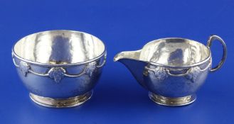 A George V Arts & Crafts silver cream jug and sugar bowl by Albert Edward Jones, with planished