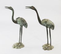 A pair of patinated bronze cranes, each on a naturalistic base, tallest 27.5in.