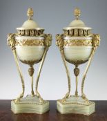 A pair of Empire style ormolu mounted green onyx lidded urns, with pineapple finials, ram mask