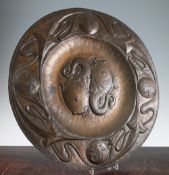 A John Pearson Arts & Crafts circular copper charger, centred with two stylised fish, the wide