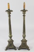 A pair of decorative brass altar sticks, modelled as large candlesticks, with fluted tapering