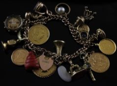 An Edwardian 9ct gold curb link charm bracelet with heart-shaped clasp, and hung with twenty