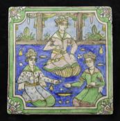 A Persian Qajar dynasty moulded polychrome pottery tile, decorated under the glaze with an