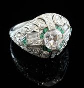 An Art Deco style platinum and iridium, emerald and diamond cluster dress ring, of filligree design,