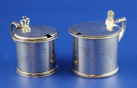 Two Victorian silver drum mustards, one with engraved lid with armorial, both with blue glass