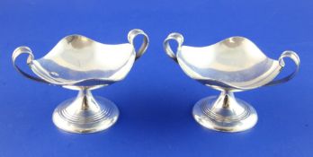 A stylish pair of George V silver two handled pedestal bon bon dishes, of quatrefoil form, with