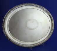 A late Victorian silver oval meat dish, with gadrooned border and engraved oval vacant cartouche,