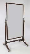 A Regency mahogany and ebony line inlaid cheval mirror, with turned upright pole supports with brass