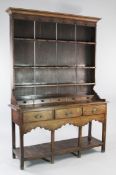 An 18th century oak dresser, the plate rack fitted with three shelves above three frieze drawers