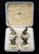 A set of four cold painted bronze menu holders, modelled as wildfowl and game birds, on circular