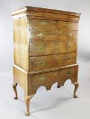 An early 18th century walnut chest on stand, with cushion frieze drawer over two short and three