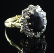 A 1970's 18ct gold, sapphire and diamond cluster ring, with pierced scroll shoulders, in an R & S