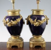 A pair of Louis XVI style ormolu mounted blue pottery table lamps, with floral swags on shaped