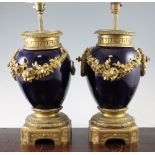 A pair of Louis XVI style ormolu mounted blue pottery table lamps, with floral swags on shaped