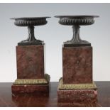 A pair of gadrooned bronze urns, on square rouge marble pedestals, with ormolu mounts, 9.5in.