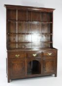 An 18th century oak dresser, the plate rack with three fitted shelves above three frieze drawers