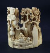 A Chinese mammoth ivory carving of Luohan, amid rockwork, resting upon a large gourd, a censer
