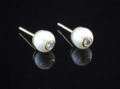 A pair of gold and cultured pearl ear studs, each inset with a round brilliant cut diamond.