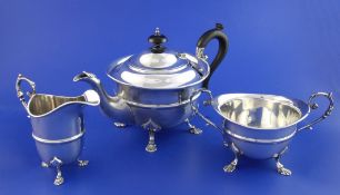 An Edwardian three piece silver tea set, of circular form, with banded girdle, on shell feet,