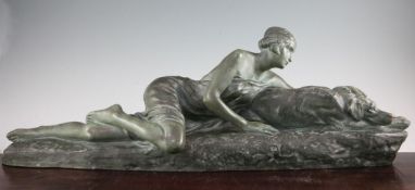 Louis Riche. A French Art Deco green painted terracotta model of a reclining female and hound,