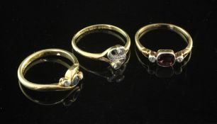 Three Edwardian 18ct gold and gem set rings, including three stone diamond and garnet and two