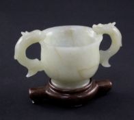 A Chinese bowenite jade two handled cup, Ming dynasty or later, of baluster form, applied with a