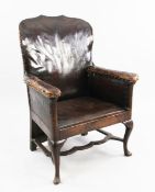 An 18th century boarded oak framed armchair, now with brass studded leather upholstery, with