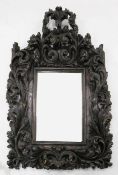 A 17th / 18th century Portuguese baroque carved chestnut wall mirror, decorated with pierced