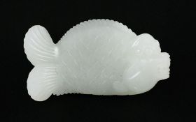 A Chinese white jade carving of dragon-fish, with cross-hatched scales to its body, 8.5cm.